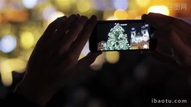 手里拿着智能手机拍摄照明传统圣诞树和大教堂在旧<strong>镇</strong>广场，捷克首都布拉格。欧洲的圣诞节