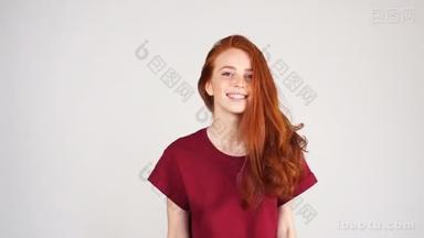 漂亮开朗的红头发的女孩笑在<strong>相机</strong>上的白色背景在慢动作.