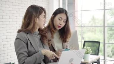 两位亚洲年轻的创意女商人拿着一杯咖啡, 在<strong>笔记本</strong>电脑上工作, 在办公室工作时讨论工作。休闲商务, 咖啡厅自由工作, 社会会议理念.