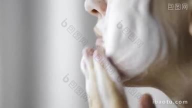 女人正在用有机泡沫肥皂洗脸，近距离侧<strong>视</strong>.