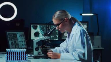 一位女<strong>科学家</strong>用显微镜进行观察并记录