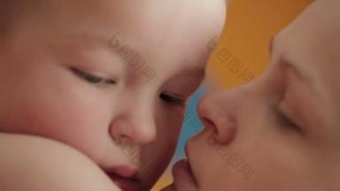 母亲微笑环抱并轻轻亲吻幼儿宝宝