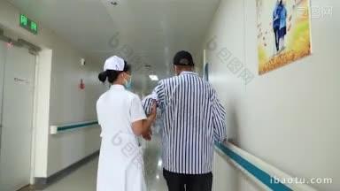 4K医疗_ 一名护士搀扶病人在走廊行走