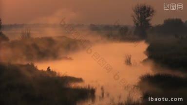 渔夫早晨在雾蒙蒙的湖面上