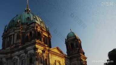 场景显示了柏林大教堂在夕阳余晖中渡过了一群雄伟的候鸟