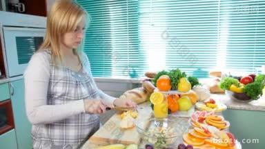 在厨房切<strong>橙子</strong>做水果沙拉的孕妇