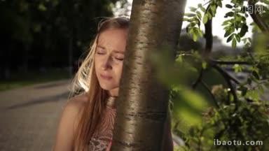 失望的女人把头靠在公园的树干上，沮丧的<strong>女孩</strong>，眼睛充满了<strong>悲伤</strong>