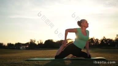 侧视图惊人<strong>的</strong>成人运动妇女练习传统瑜伽姿势在公园做<strong>鸽子</strong>瑜伽姿势在绿色