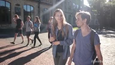 美丽的学生情侣走在大学校园里拿着书聊天