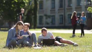 快乐的大学生坐在大学校园的绿色草地上，一边使用笔记本<strong>电脑</strong>和平板<strong>电脑</strong>，一边在<strong>户外</strong>学习