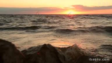 风景如画的海景和岩石海岸在橙色落日的光芒下神秘的日落在海上和