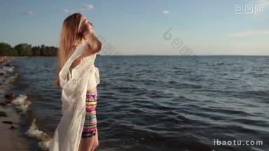 迷人的年轻金发女子深呼吸<strong>享受</strong>新鲜空气在阳光明媚的沙滩上的夏天
