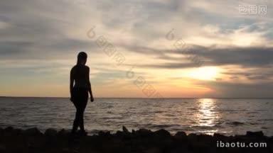 健身女孩在海边享受海景与手臂向上举起朝向天空在美丽的<strong>日落</strong>背面的辉光