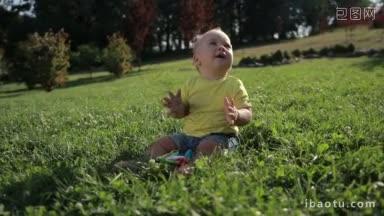 <strong>可爱</strong>的小婴儿画像坐在绿色的草地上，拍着他的手微笑甜美的学步