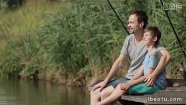 快乐的<strong>父亲</strong>坐在池塘边的木码头上钓鱼，用爱和<strong>温柔</strong>拥抱着十几岁的儿子