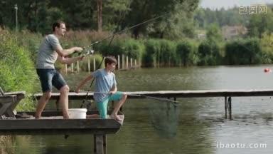 钓鱼者带着纺线杆和卷轴在池塘里钓鱼，周末带着儿子在乡下的湖边