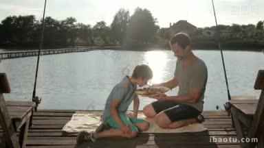 正儿子闻着美味炸鱼的香味，父亲和儿子坐在木码头上