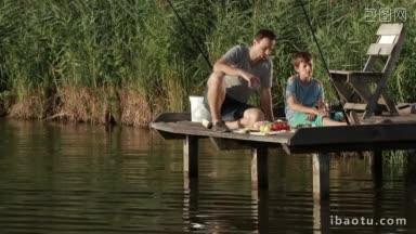 悠闲的父亲和儿子坐在木浮筒上，在<strong>湖</strong>边享受美食，在<strong>乡村风景</strong>背景下度过周末