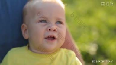 可爱的蓝<strong>眼睛</strong>婴儿的肖像，他坐在父亲的手在阳光明媚的夏日好奇