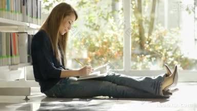 女大学生坐在<strong>图书馆</strong>的地板上看书和做笔记