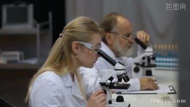 迷人的年轻<strong>女</strong>科学家和她的高级男主管在生命科学研究实验室吸液和显微镜年轻<strong>女</strong>