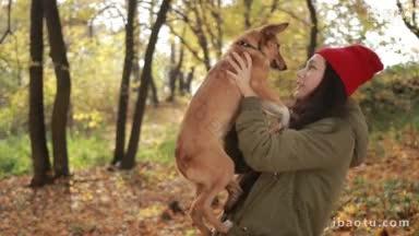 画像美丽的潮女孩在<strong>时尚</strong>的服装抱着她可爱的小狗和微笑在公园在金色的秋天