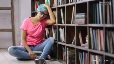 沮丧的女大学生戴着眼镜，考试不及格，坐在图书馆的地板上，靠在书架上