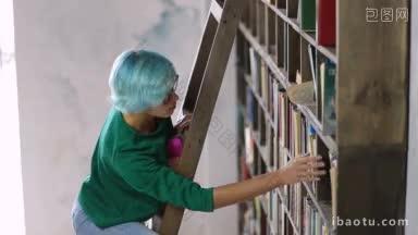 戴眼镜的年轻女大学生站在<strong>木梯子</strong>上，在图书馆的书架上找书