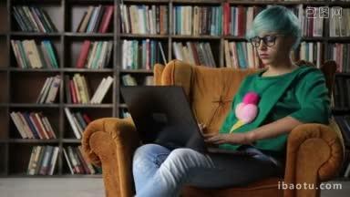 快乐的成功的自由职业者女孩在眼镜上工作在她的笔记本电脑，而坐在舒适的<strong>椅子</strong>在家里的书架<strong>背景</strong>