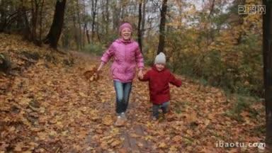 可爱的十几岁的女孩戴着眼镜，拿着黄色的枫叶和她可爱的蹒跚学步的弟弟在秋天的公园里奔跑快乐的兄弟姐妹