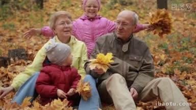 快乐的爷爷奶奶和孙子孙女一起在秋天的公园里悠闲地玩耍