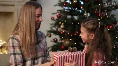 快乐美丽的母亲从可爱的女儿收到圣诞礼盒装饰圣诞房间背景快乐的小女孩