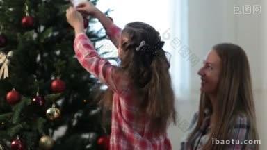 可爱的小女儿在<strong>圣诞树</strong>上挂着<strong>装饰</strong>品，和她美丽的妈妈一家人在家里<strong>装饰</strong>家庭<strong>圣诞树</strong>