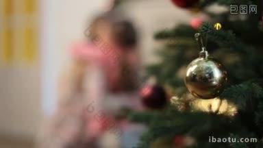 前景的玻璃<strong>装饰物</strong>在圣诞树的树枝和模糊的幸福的母亲和女儿抱着玩耍和玩馅饼<strong>蛋糕</strong>