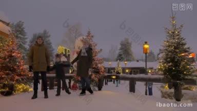 幸福的父母带着孩子在装饰着圣诞彩灯的雪景公园里牵着手