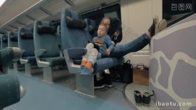 孩子和妈妈坐火车旅行，疲惫的男孩拿着平板电脑躺在座位上，靠在妈妈身上