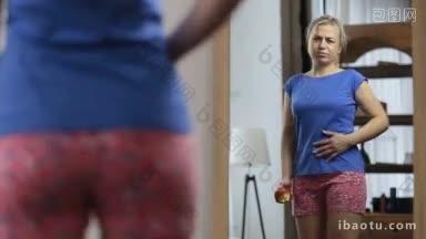 一个心烦意乱的女人一边吃着苹果，一边看着镜子里自己的倒影，对自己的身材不满意