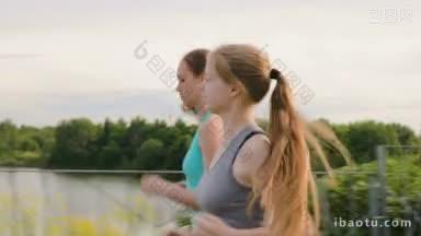 两个女孩沿着公园里美丽的湖边的步道跑步