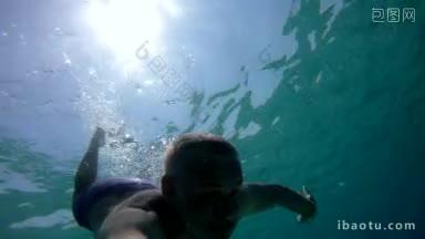 男子在水下自由潜水，手持gopro摄像机