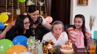 潘老母带着女儿和孙女们在生日派对上吹蜡烛庆祝生命和爱的概念