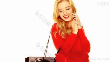 时尚肖像一个时髦的微笑的金发女人在红色套装使用白色的<strong>手机</strong>
