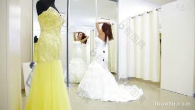 年轻迷人的女人在新娘精品店选择婚纱