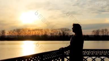美丽的<strong>女士剪影</strong>花在侧面附近清澈的湖日落