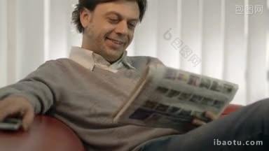 画像快乐的白人成年男子坐在家里的沙发上阅读报纸上的房<strong>地产广告</strong>和谈话