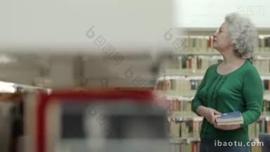 老退休妇女的肖像在图书馆选择书，并从架子上取下它拍摄