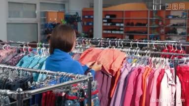 在一家服装店选购衣服的年轻女子正在挑选<strong>儿童</strong>夹克