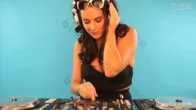 迷人的微笑女DJ混音戴着立体声耳机，她听着音乐和点击