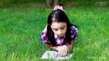 小女孩在夏日公园的<strong>草地</strong>上看书