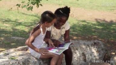 年轻人和教育两个小女孩在城市<strong>公园</strong>读书