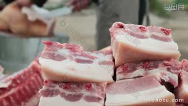 背景中街边市场卖猪肉的屠夫正在切新鲜的猪肉